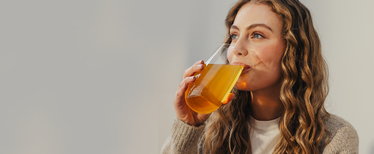 Woman drinking a glass of orange Phizz