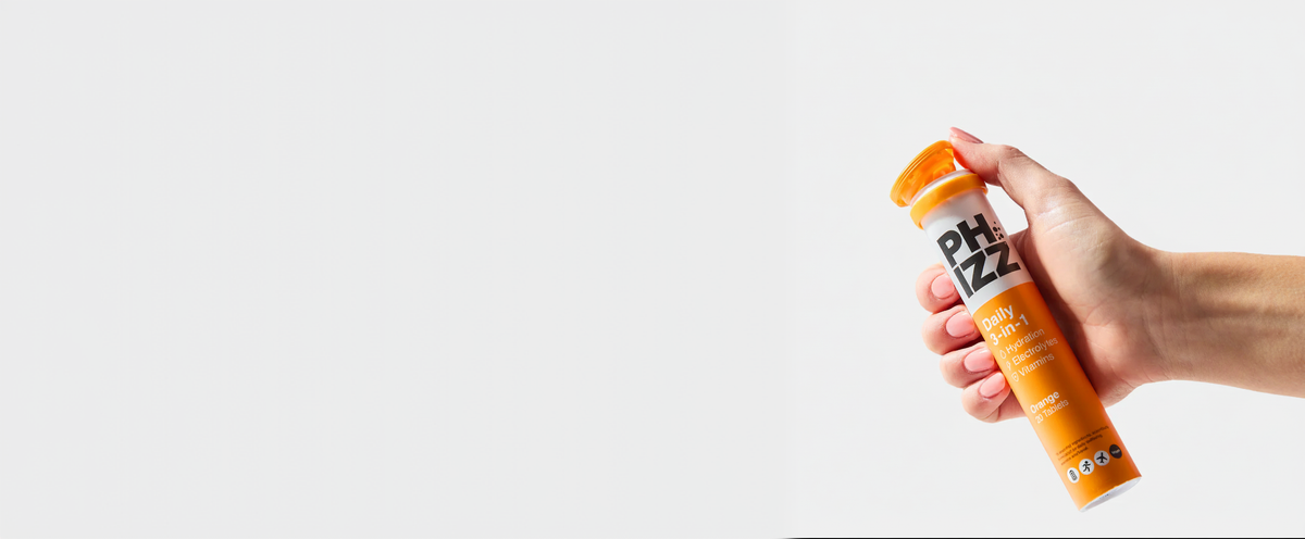 Hand holding a Phizz Daily 3-in-1 Orange tube