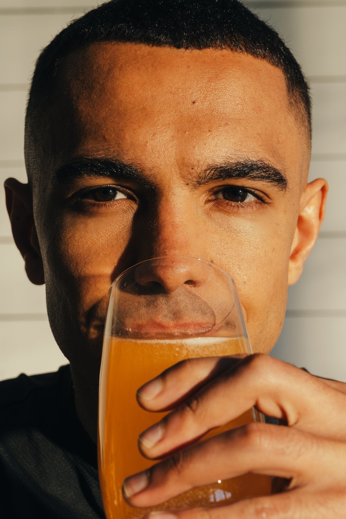 Close-up of a person drinking a glass of orange Phizz