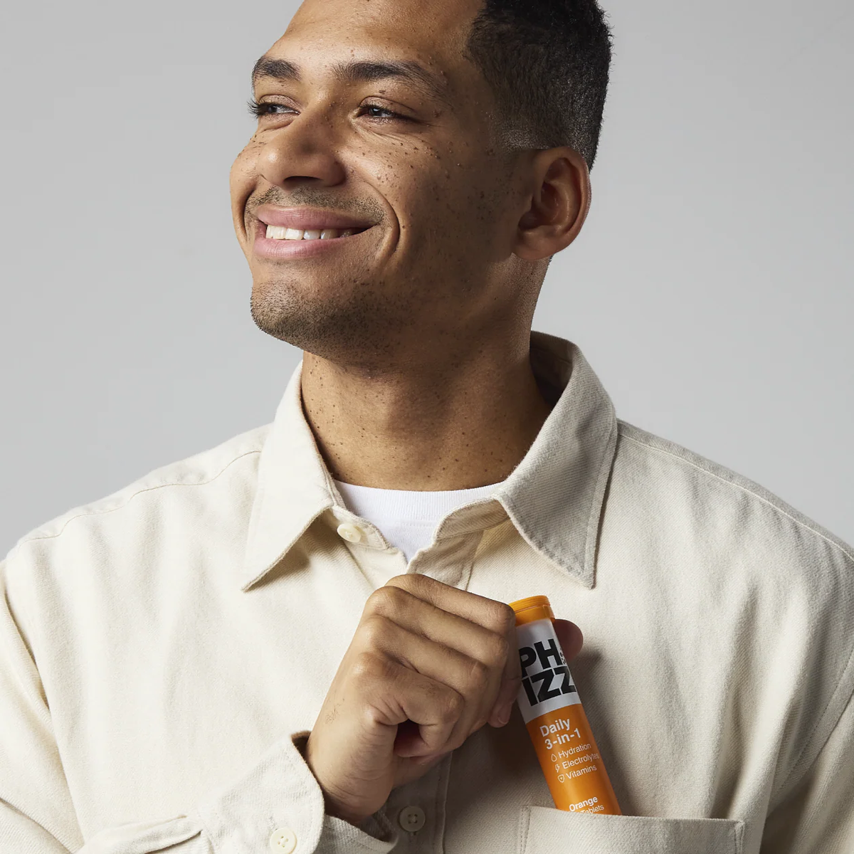 Smiling man holding a Phizz tube